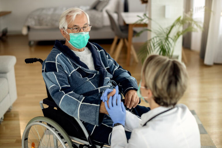 Pflegebedürftiger Senior mit Medizinischer Gesichtsmaske zum Schutz